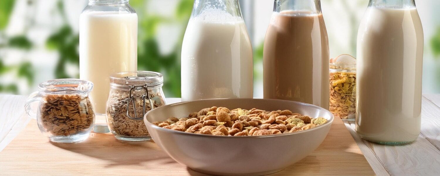Prato saudável com opções de alimentos sem glúten e sem lactose, incluindo quinoa, legumes frescos e leite vegetal.